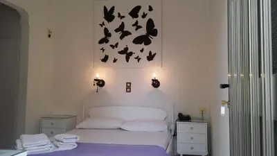 a bedroom with a bed with bats on the wall at Rachel Hotel in Agia Marina Aegina