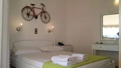 a bedroom with a bed with a bike on the wall at Rachel Hotel in Agia Marina Aegina