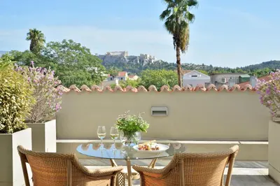 a patio with a table with wine glasses on it at Athenaeum Eridanus Luxury Hotel in Athens