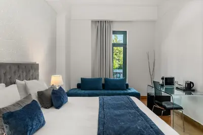 a bedroom with a large bed and a couch at Athenaeum Eridanus Luxury Hotel in Athens