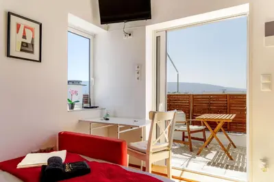 a room with a bed and a table and a balcony at The Terrace with Acropolis & Athens view in Athens