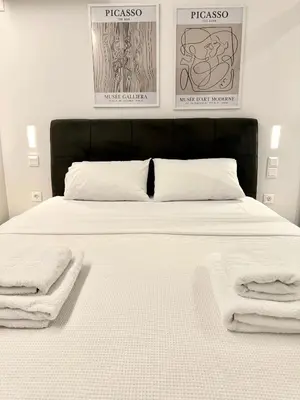 a bed with white sheets and towels on it at JV Athens in Athens