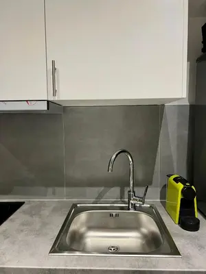 a stainless steel kitchen sink with a yellow appliance at JV Athens in Athens
