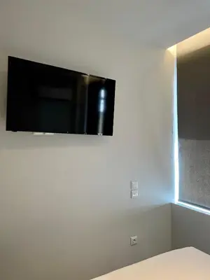 a flat screen tv hanging on a white wall at JV Athens in Athens