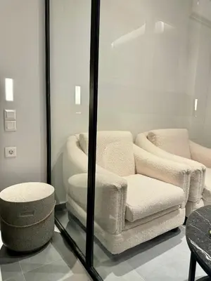 a living room with a chair and a ottoman at JV Athens in Athens