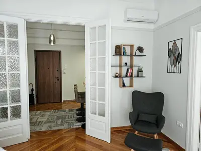a living room with a chair and a hallway at Plaka Sofi Suite in Athens