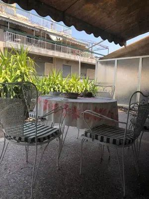 a table and chairs on a patio with plants at Spacious Double room in the Center of Athens in Athens