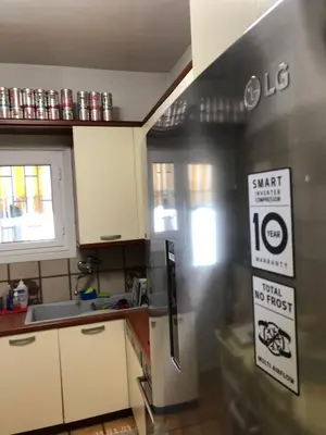 a kitchen with a stainless steel refrigerator with signs on it at Spacious Double room in the Center of Athens in Athens