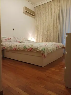 a bed in a bedroom with a wooden floor at Spacious Double room in the Center of Athens in Athens