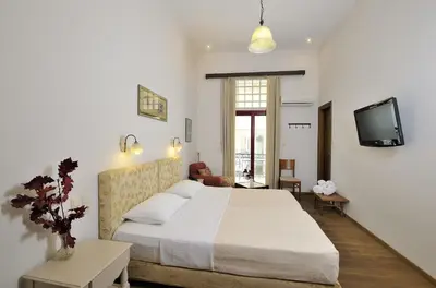a bedroom with a large bed and a tv at Dryades & Orion Hotel in Athens