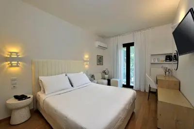 a bedroom with a large white bed and a desk at Dryades & Orion Hotel in Athens