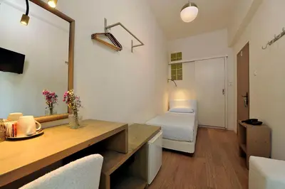 a room with a desk and a bedroom with a bed at Dryades & Orion Hotel in Athens