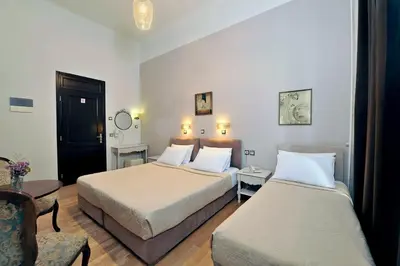 a hotel room with two beds and a chair at Dryades & Orion Hotel in Athens