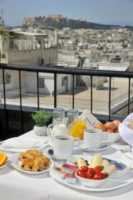 a table with plates of breakfast food on a balcony at Dryades & Orion Hotel in Athens
