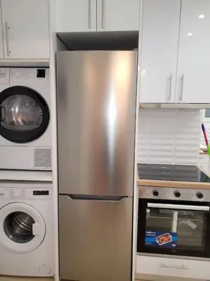 a stainless steel refrigerator in a kitchen next to a washer at Acropolis Thisio Apartment 2 bedrooms 2 bathrooms in Athens