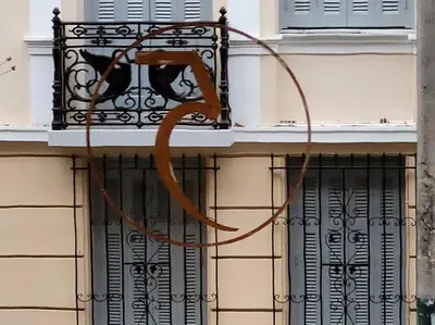 a black cat sitting on a balcony of a building at Acropolis Thisio Apartment 2 bedrooms 2 bathrooms in Athens