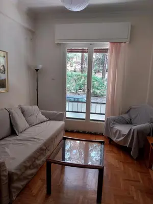 a living room with a couch and a window at Park-view apartment in Athens