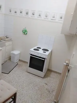 a white kitchen with a stove top oven in it at Park-view apartment in Athens