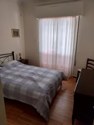 a bedroom with a bed and a large window at Park-view apartment in Athens