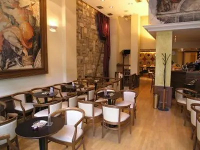 a restaurant with tables and chairs and a painting on the wall at Athens City Hotel in Athens