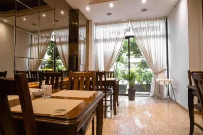 a dining room with tables and chairs and windows at Athens City Hotel in Athens