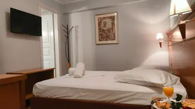 a hotel room with a bed and a television at Athens City Hotel in Athens