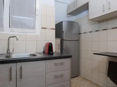 a kitchen with a sink and a refrigerator at Alluring 2BR apartment in Thiseio in Athens