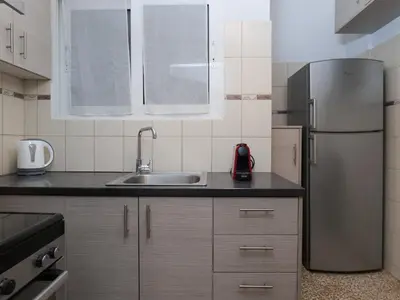 a kitchen with a stainless steel refrigerator and a sink at Alluring 2BR apartment in Thiseio in Athens