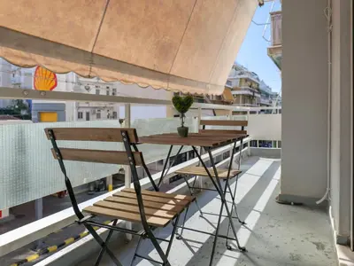 a table and chairs on the balcony of a building at Alluring 2BR apartment in Thiseio in Athens