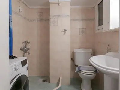 a bathroom with a toilet and a sink and a washing machine at Alluring 2BR apartment in Thiseio in Athens