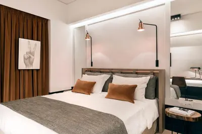 a bedroom with a large bed with brown pillows at Niki Athens Hotel in Athens