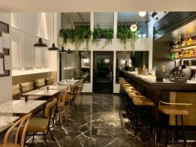 a restaurant with tables and chairs and a bar at Niki Athens Hotel in Athens