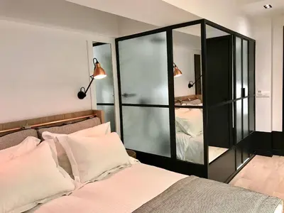 a bedroom with a bed and a glass cabinet at Niki Athens Hotel in Athens
