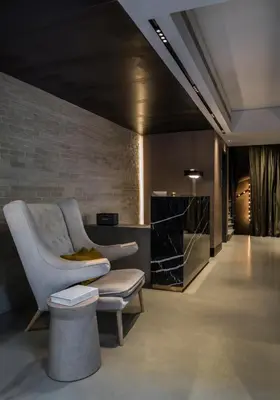 a living room with a chair and a table at Niki Athens Hotel in Athens