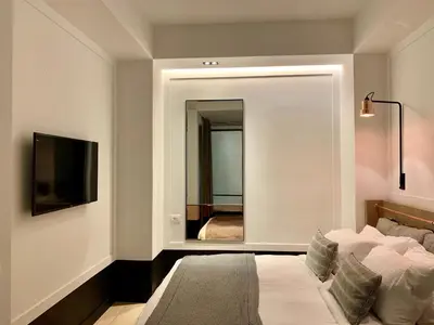 a bedroom with a bed with a mirror and a television at Niki Athens Hotel in Athens