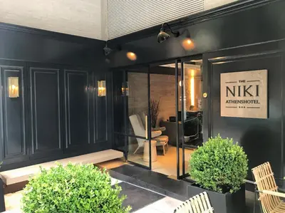 a store front with a bench and a chair at Niki Athens Hotel in Athens