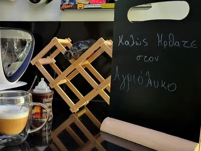 a table with a sign and a glass of beer at Agriolykos Luxury layer-Smart home-Athens city center-fully equipped in Athens