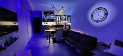 a living room with a couch and a clock on the wall at Agriolykos Luxury layer-Smart home-Athens city center-fully equipped in Athens