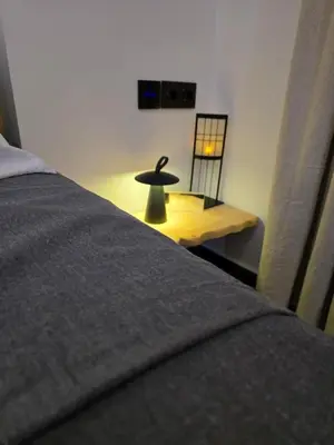 a bedroom with a bed and a table with a lamp at Agriolykos Luxury layer-Smart home-Athens city center-fully equipped in Athens