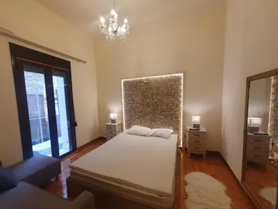 a bedroom with a bed and a mirror and a chandelier at John's Athenian Beauty 45m2 , Metro 7' in Athens