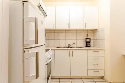 a white kitchen with a sink and a refrigerator at John's Athenian Beauty 45m2 , Metro 7' in Athens