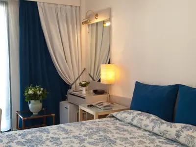 a bedroom with a bed and a table with a lamp at The Park Hotel Piraeus in Piraeus