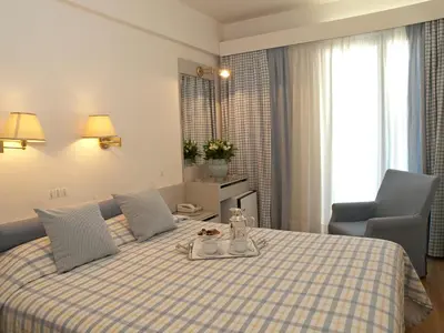 a hotel room with a bed with a tray of food on it at The Park Hotel Piraeus in Piraeus