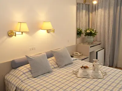 a bedroom with a bed with a plaid blanket at The Park Hotel Piraeus in Piraeus