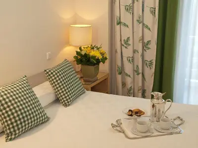 a bed with a tray with cups and saucers on it at The Park Hotel Piraeus in Piraeus