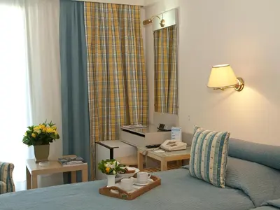 a hotel room with a bed and a table with cups on it at The Park Hotel Piraeus in Piraeus