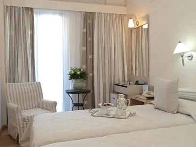 a hotel room with a bed and a chair at The Park Hotel Piraeus in Piraeus
