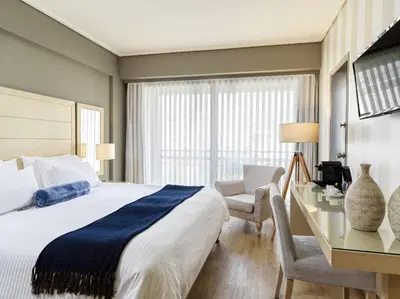 a bedroom with a bed and a desk and a chair at Sea View Cityscape Hotel in Athens