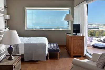 a bedroom with a bed and a window and a chair at Sea View Cityscape Hotel in Athens