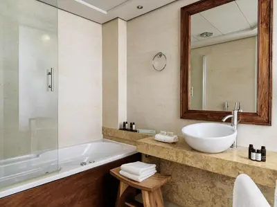 a bathroom with a tub and a sink and a mirror at Sea View Cityscape Hotel in Athens